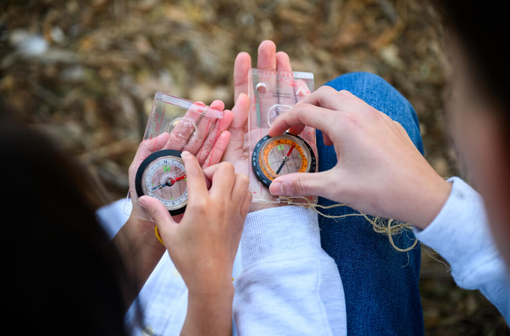 Children's hands holding a compass